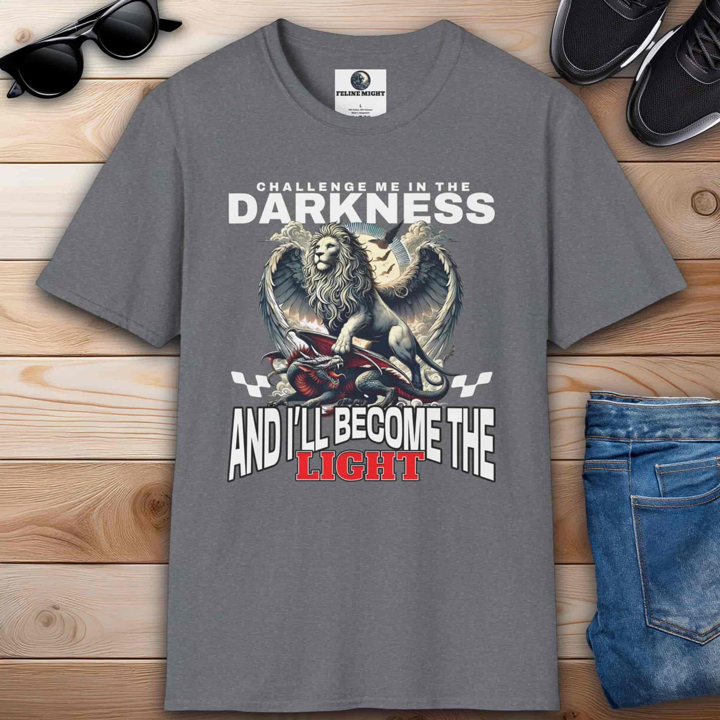 Gray t-shirt featuring a winged lion graphic with the text 'Challenge me in the darkness and I will become the light.'
