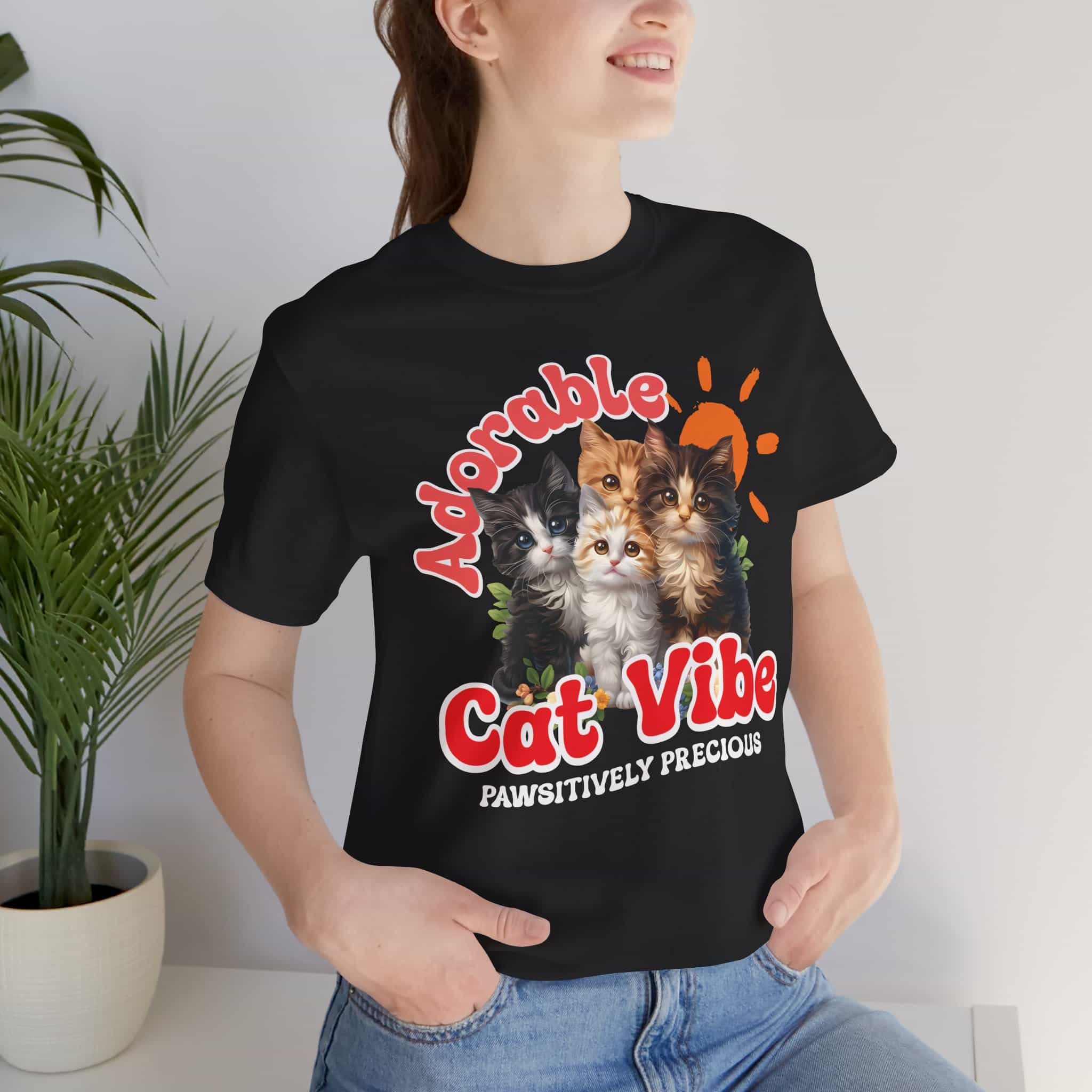 A close-up of a woman wearing a black Adorable Cat Vibe Graphic T-Shirt featuring cute cats, perfect for cat lovers who embrace their feline passion.