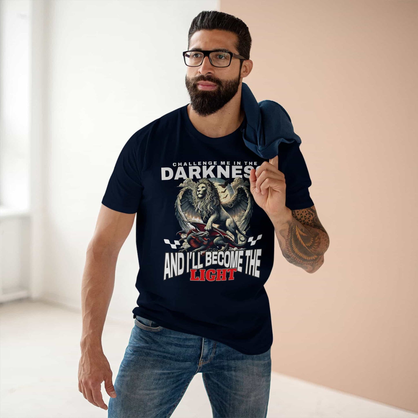 A man wearing a navy blue Challenge Me in the Darkness Lion T-Shirt featuring a majestic winged lion graphic.