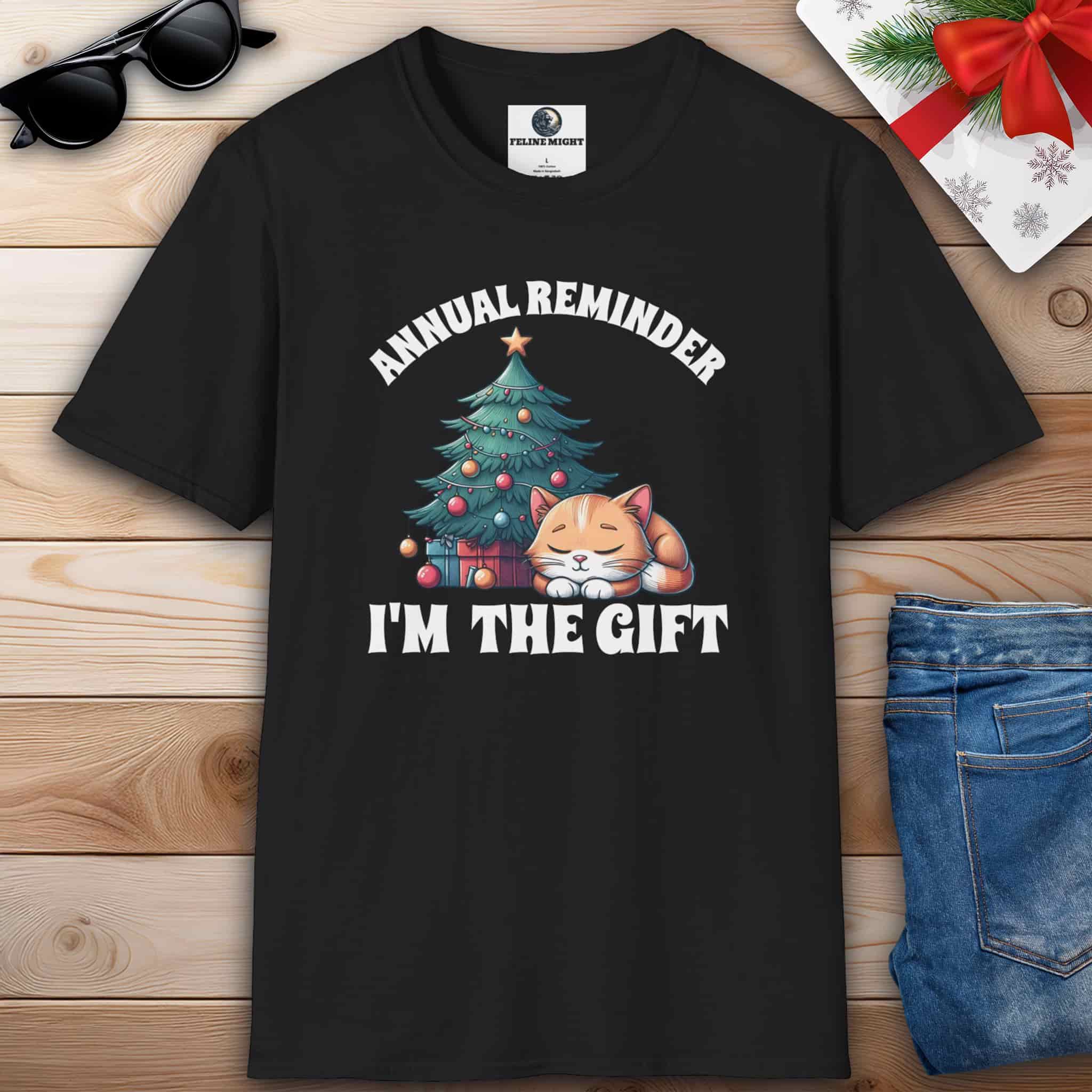 Black t-shirt with 'Annual Reminder, I'm the Gift' and a cute cat sleeping beside a Christmas tree.