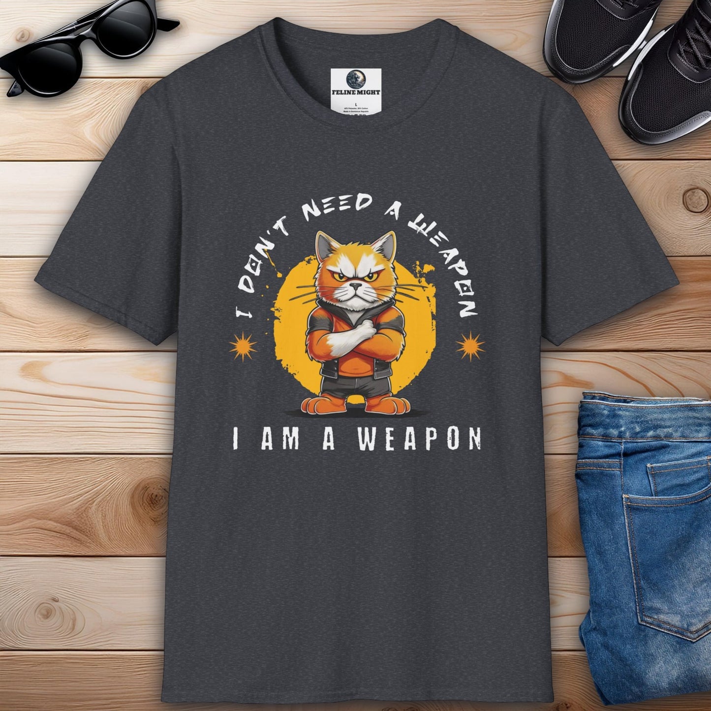 Dark heather grey t-shirt featuring a cartoon cat with the phrase 'I Don't Need A Weapon, I Am A Weapon'