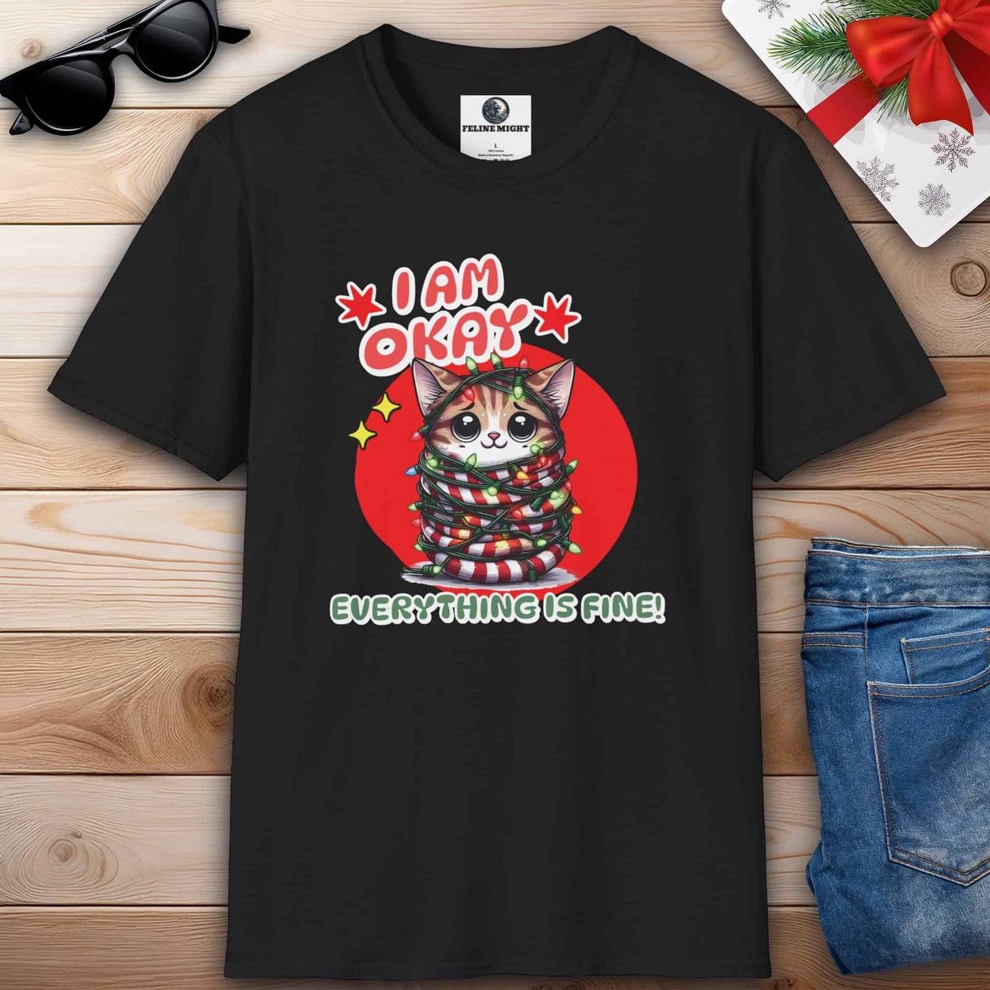 A black T-shirt featuring a cat that humorously states, "I am Okay. Everything is fine!" spreading joy and laughter during the holiday season.