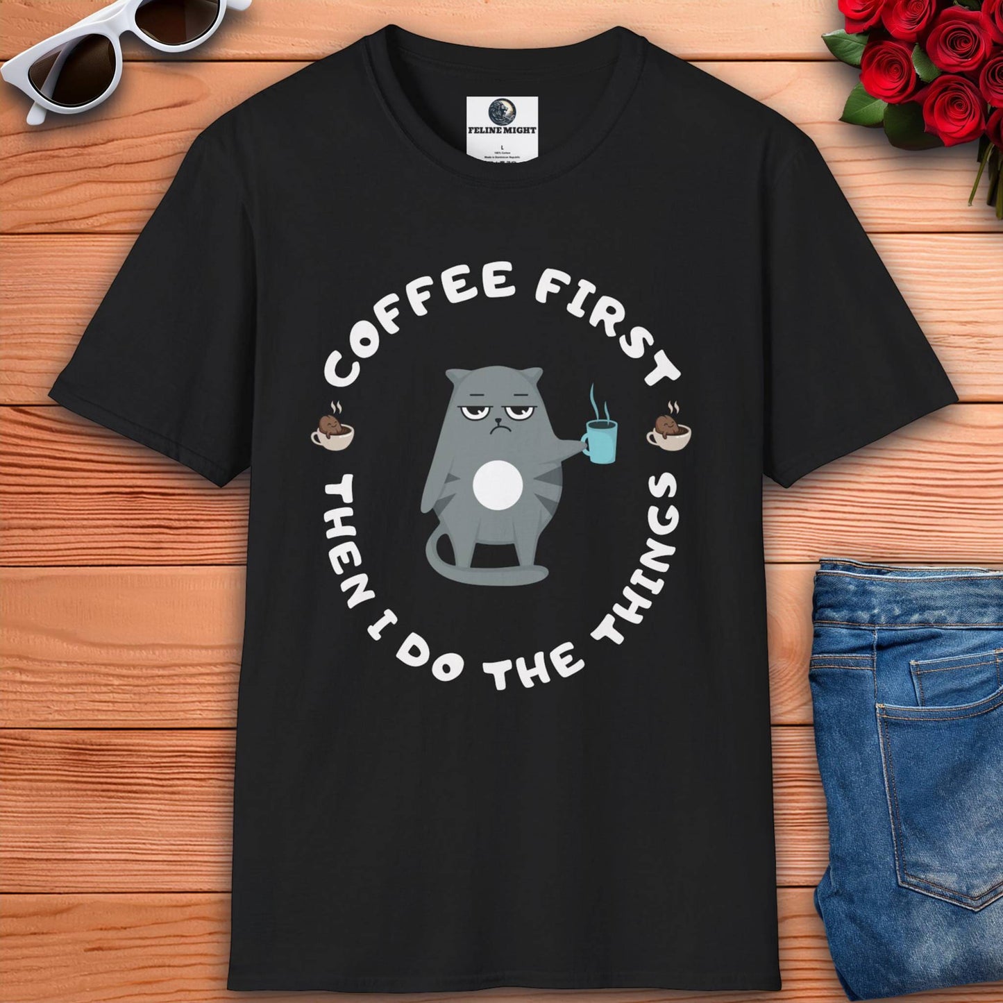 A black t-shirt featuring the phrase "Coffee first, then I do the things" in a stylish font, perfect for coffee lovers.