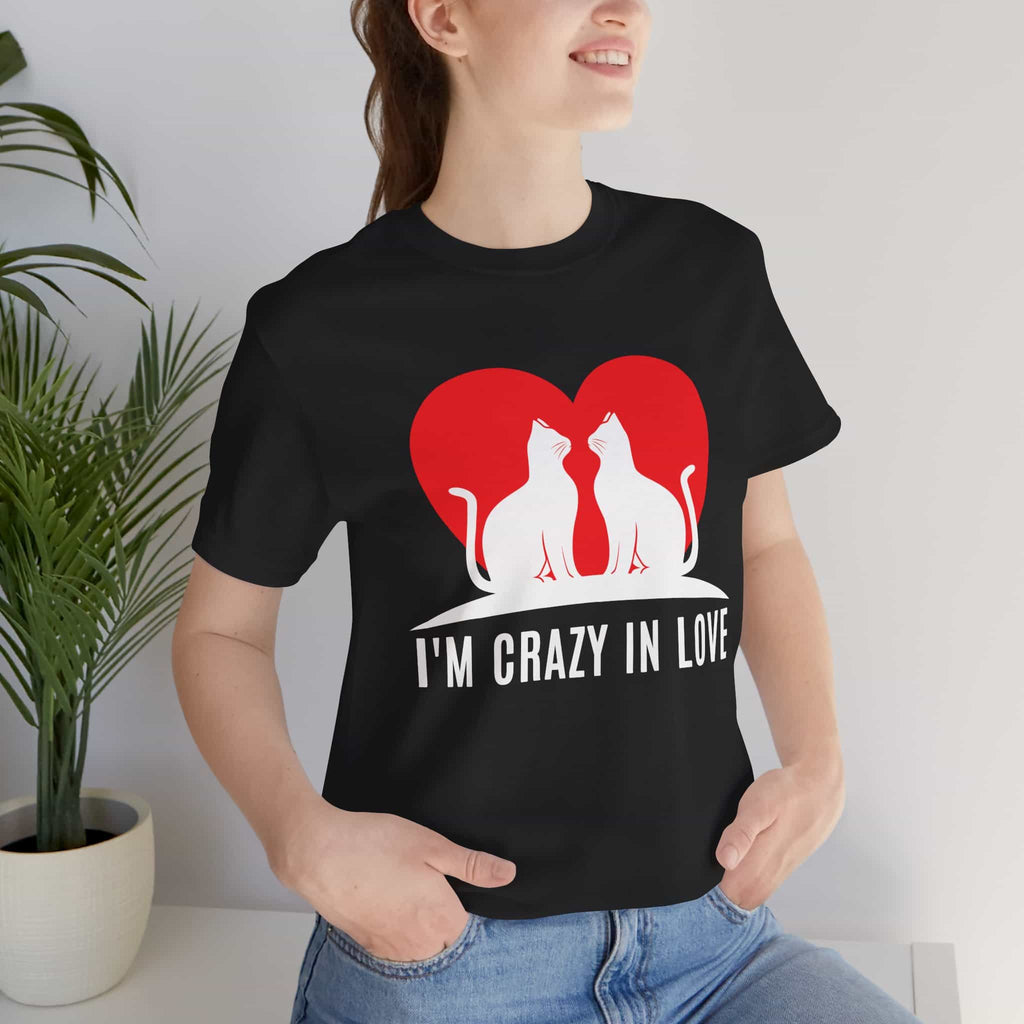 A woman in a black I'm Crazy in Love Cat T-Shirt featuring two cats with a heart design, perfect for romantic cat lovers.