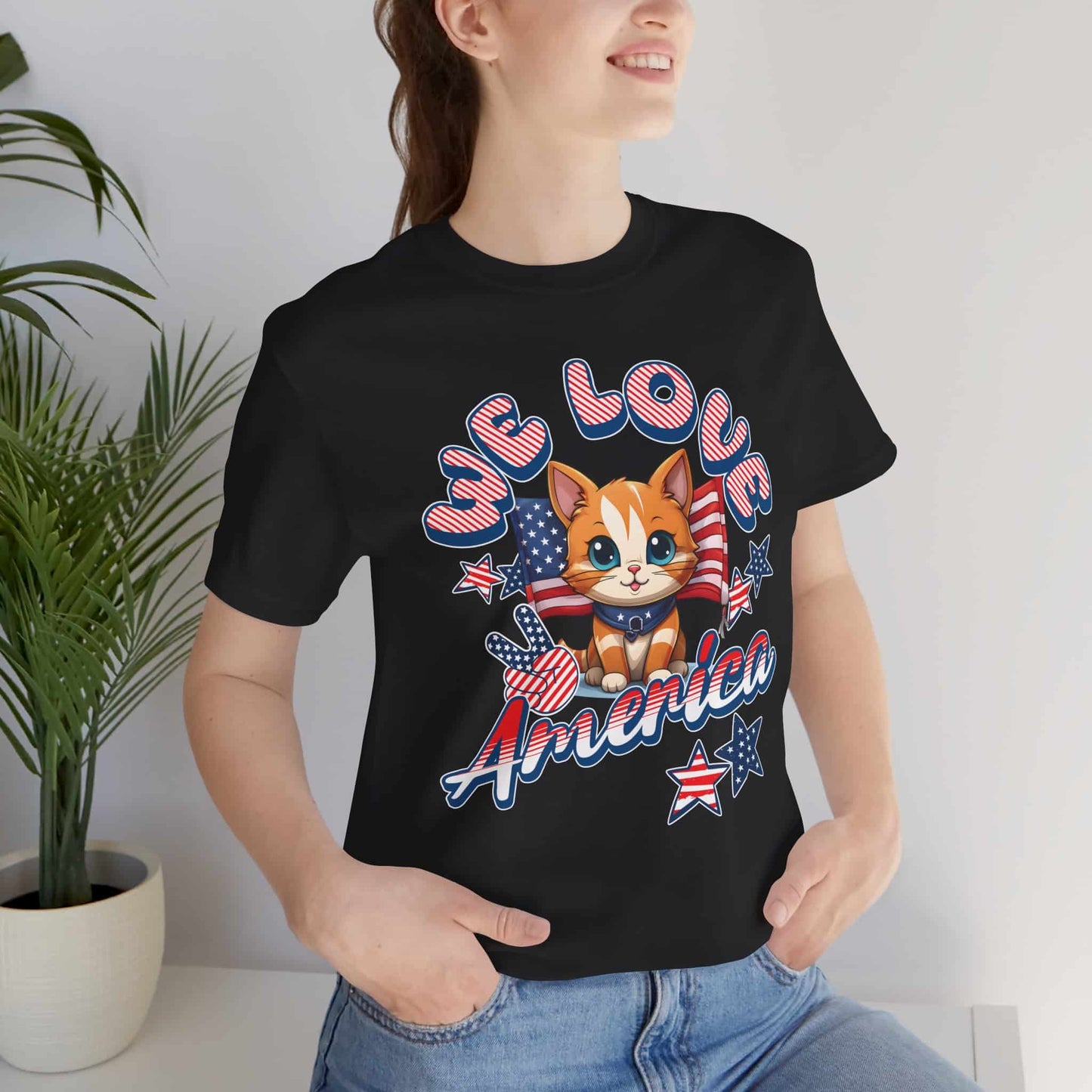 A woman in a black Cute Patriotic Cat T-Shirt with a cheerful red, white, and blue cat design and the text “We Love America.”