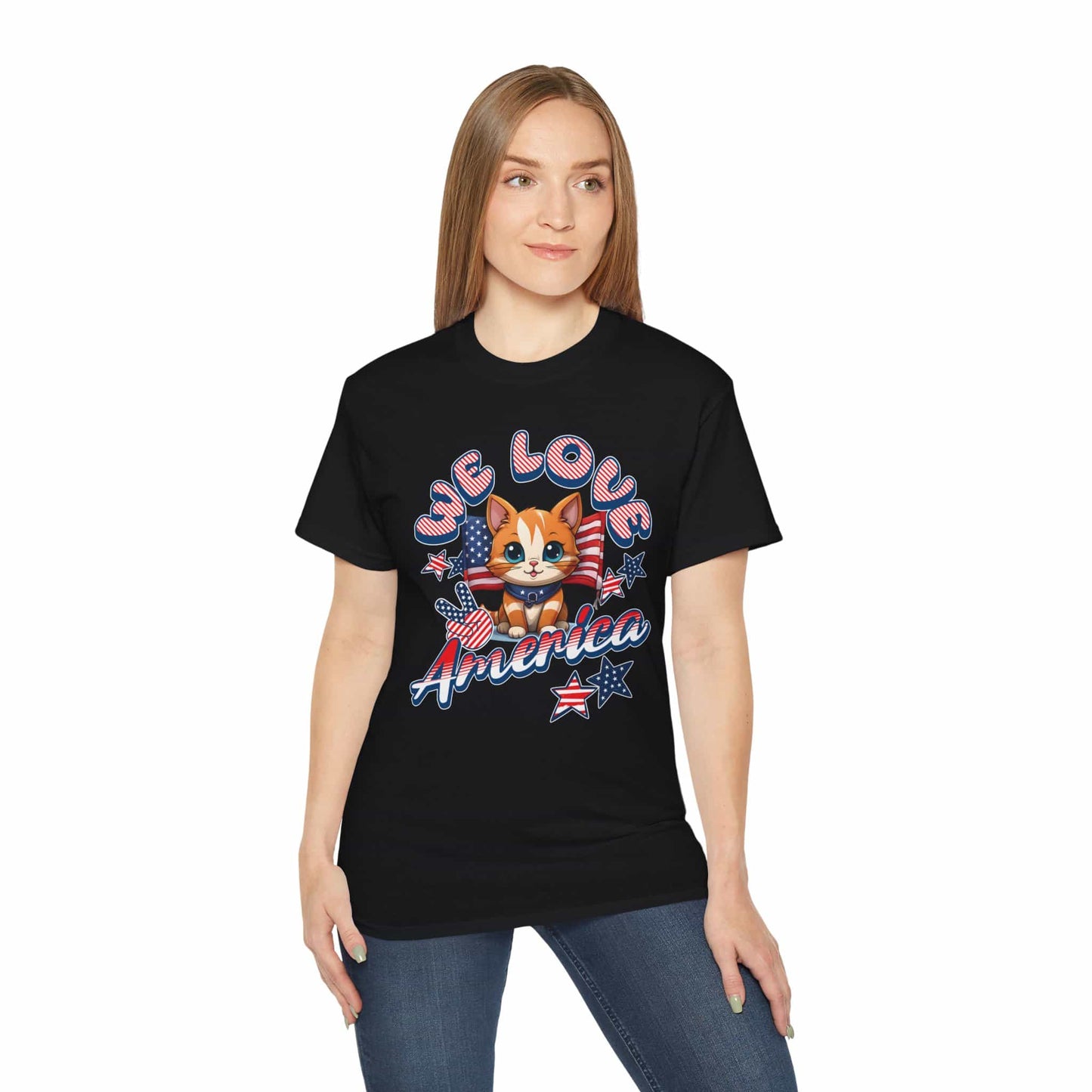 A woman wearing a black Cute Patriotic Cat T-Shirt featuring a cheerful cat illustration in red, white, and blue with the text “We Love America.”