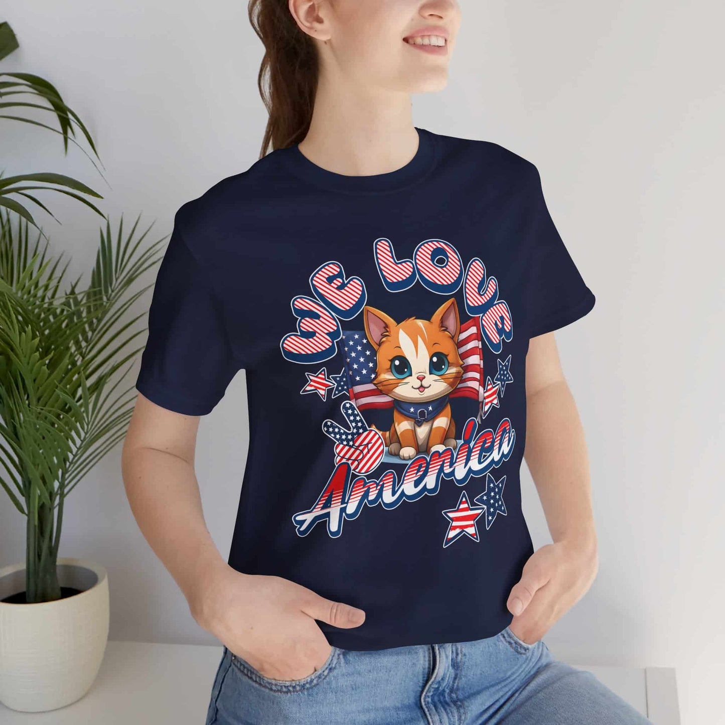 A woman in a navy blue Cute Patriotic Cat T-Shirt with a cheerful red, white, and blue cat design and the text “We Love America.”
