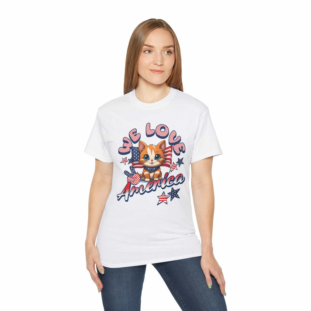 A woman wearing a white We Love America T-Shirt featuring a cheerful cat illustration in red, white, and blue with the text “We Love America.”