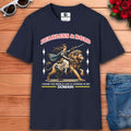 A navy blue Fearless Lioness Women's T-Shirt featuring a sword-wielding queen and lion design on a wooden surface with sunglasses and jeans.