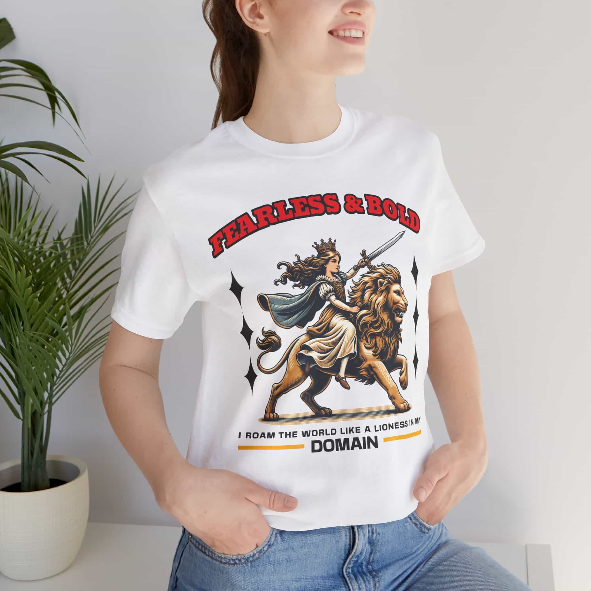 A woman wearing a white Fearless Lioness Women's T-Shirt featuring a sword-wielding queen and lion design.