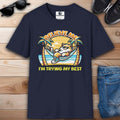 A navy blue Relatable Cat Humor T-Shirt featuring a cartoon cat relaxing in a hammock with palm trees and the text 'Believe Me I'm Trying My Best'.