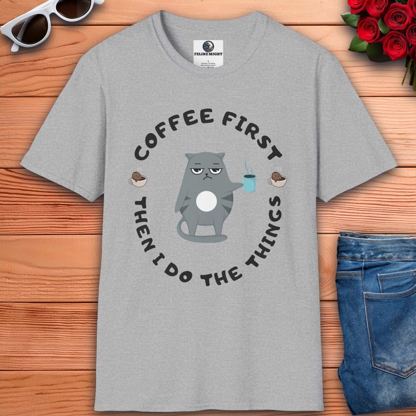 Grey t-shirt featuring a cartoon cat holding a coffee cup with the phrase 'Coffee First Then I Do The Things'