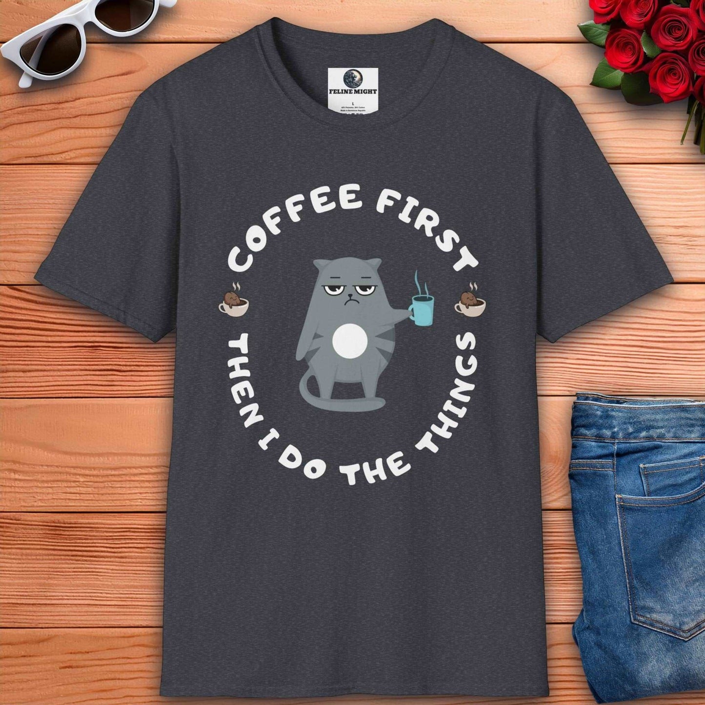 Dark heather grey t-shirt featuring a cartoon cat holding a coffee cup with the phrase 'Coffee First Then I Do The Things'