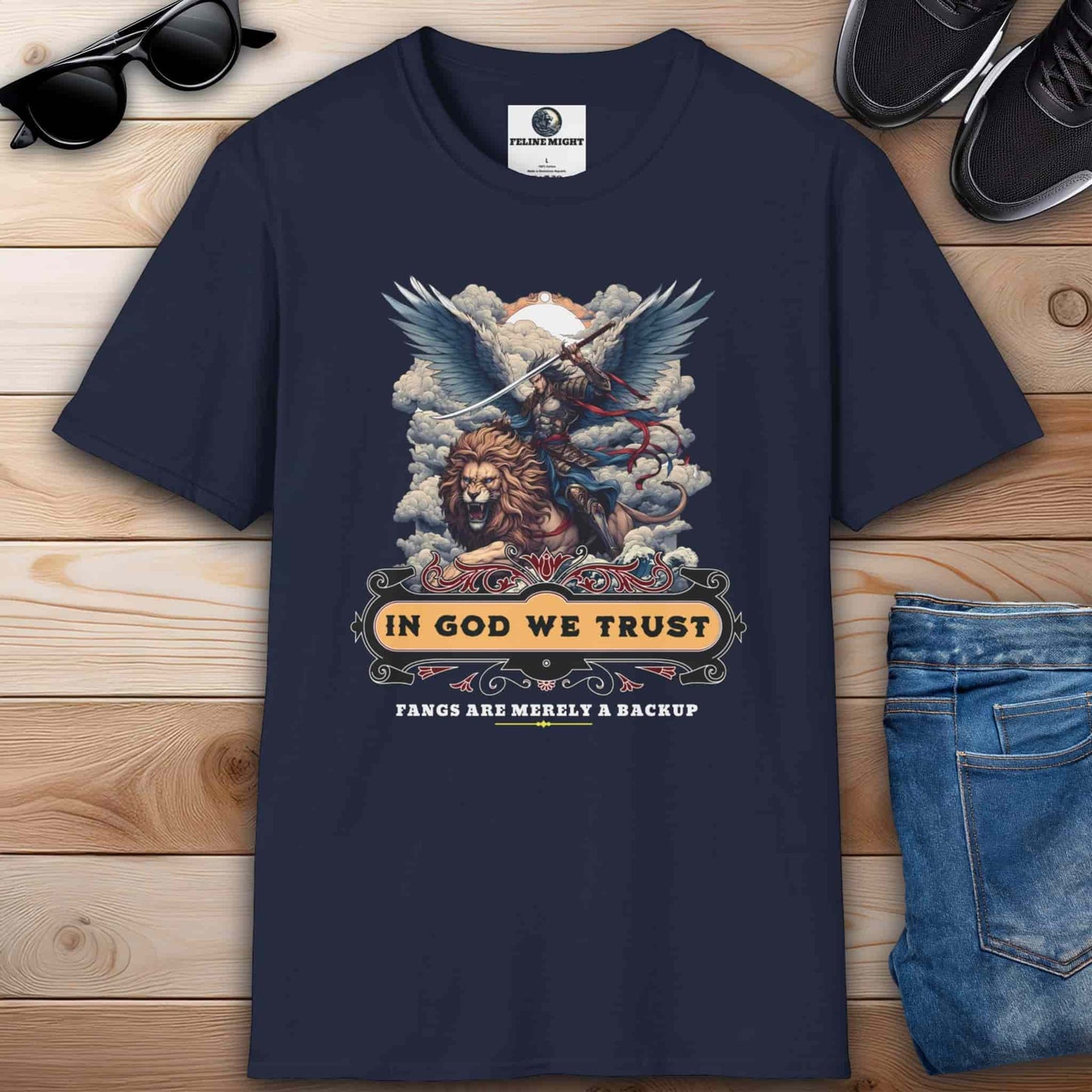 Navy blue t-shirt featuring a lion and angelic warrior design with the text 'In God We Trust. Fangs Are Merely a Backup'.