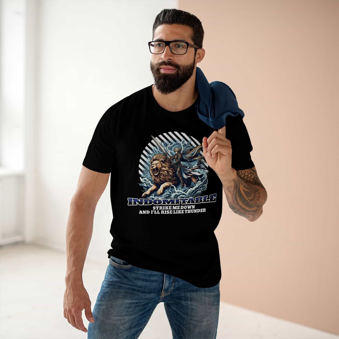 A man wearing a black Indomitable Warrior Lion T-Shirt featuring a lion and warrior graphic with motivational quote.