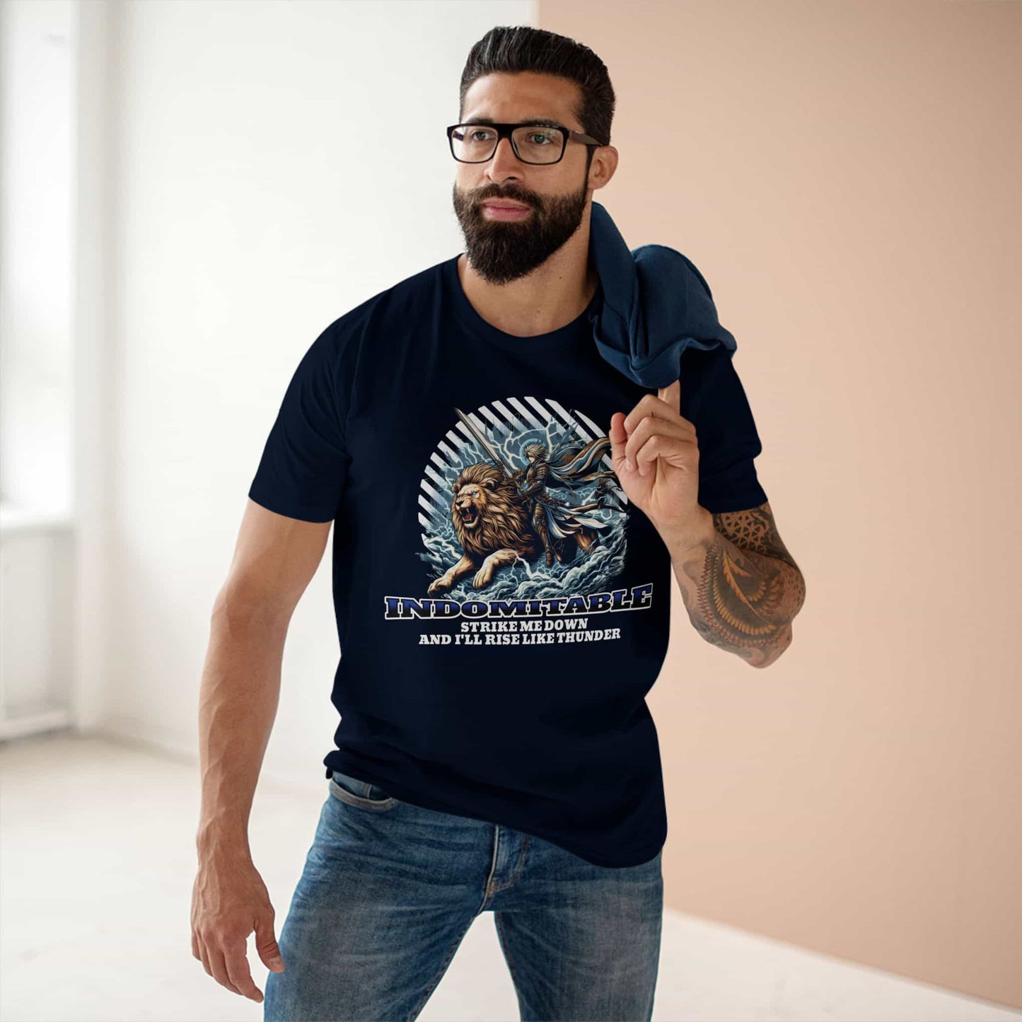 A man wearing a navy blue Indomitable Warrior Lion T-Shirt featuring a lion and warrior graphic with motivational quote.