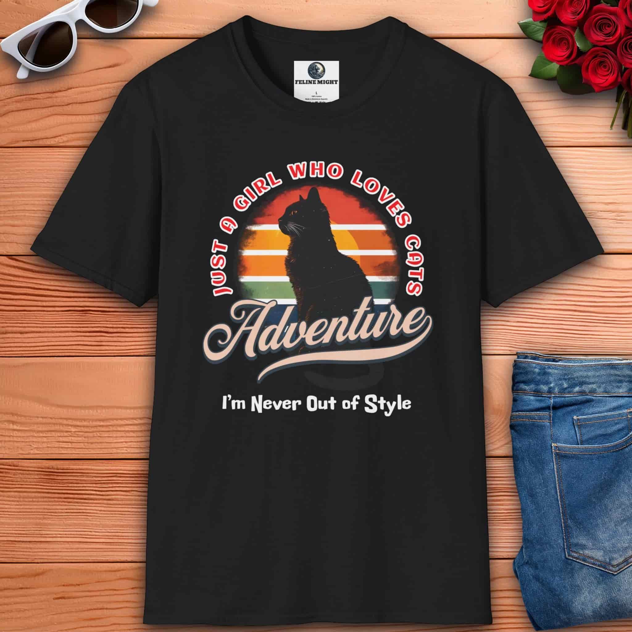 A black Just a Girl Who Loves Cats T-Shirt featuring a cat silhouette, retro adventure design, and the text "I'm Never Out of Style."