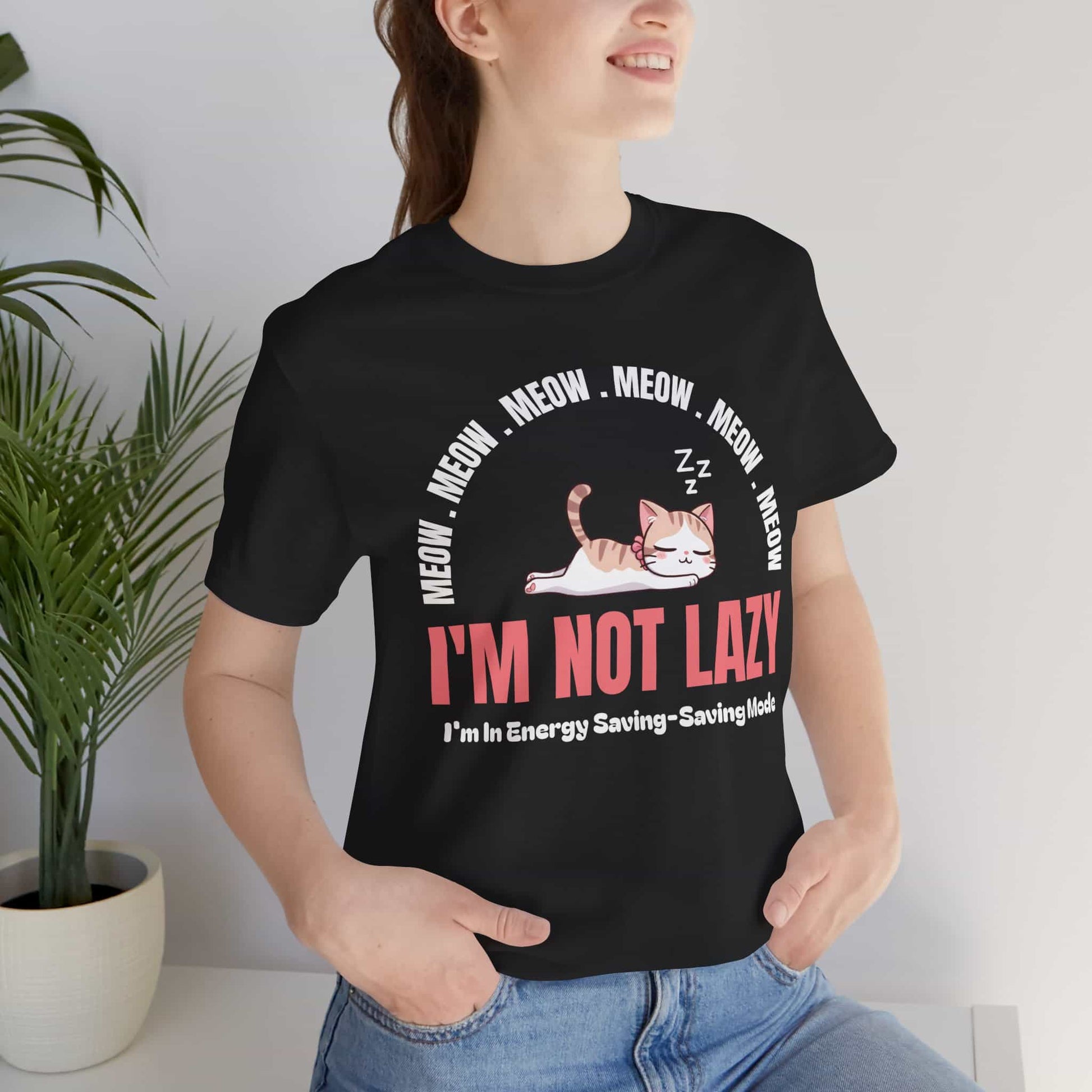 A woman wearing a black Lazy Cat Funny T-Shirt featuring a sleeping cat with text I'm Not Lazy, perfect for cat lovers and humorous fashion.