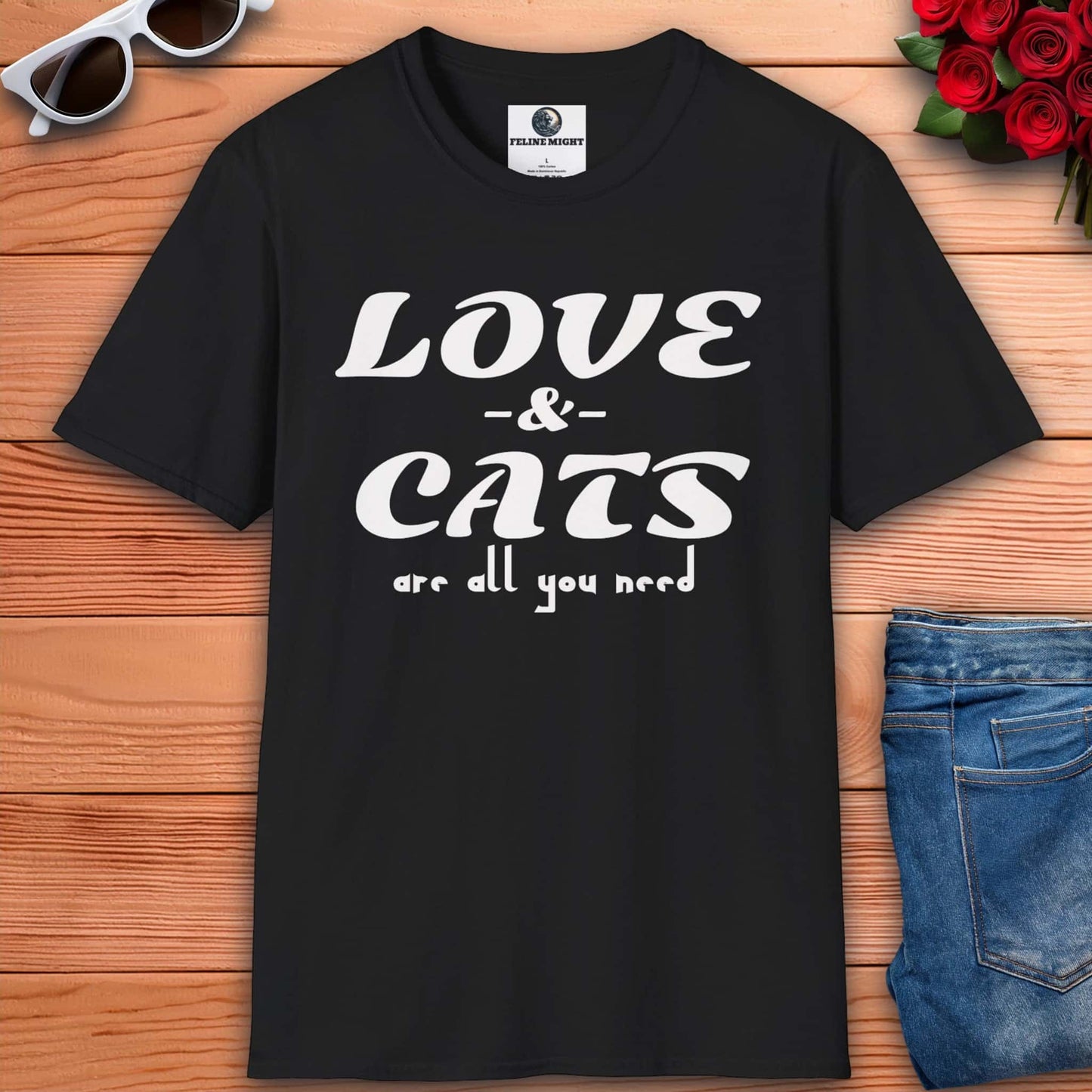 A graphic black t-shirt displaying the message "Love and Cats Are All You Need," emphasizing a passion for felines and affection.