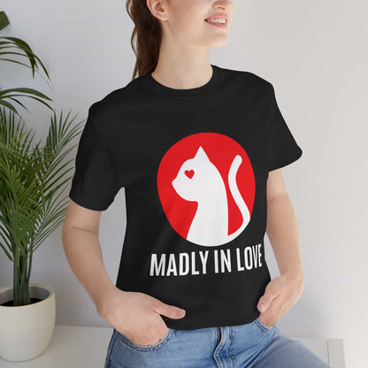 A woman in a black Madly in Love Cat T-Shirt featuring a cat silhouette on a red circle, a perfect romantic gift for cat lovers.