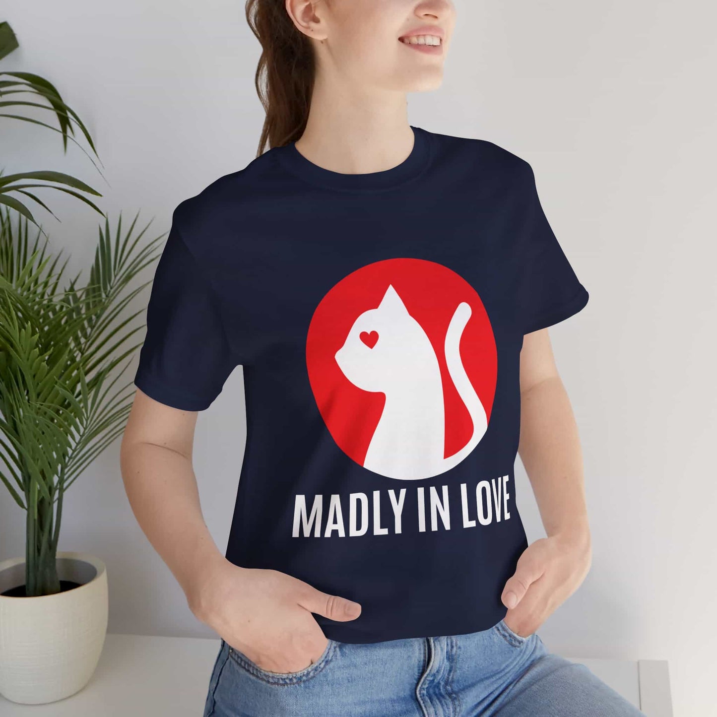 A woman in a navy blue Madly in Love Cat T-Shirt featuring a cat silhouette on a red circle, a perfect romantic gift for cat lovers.