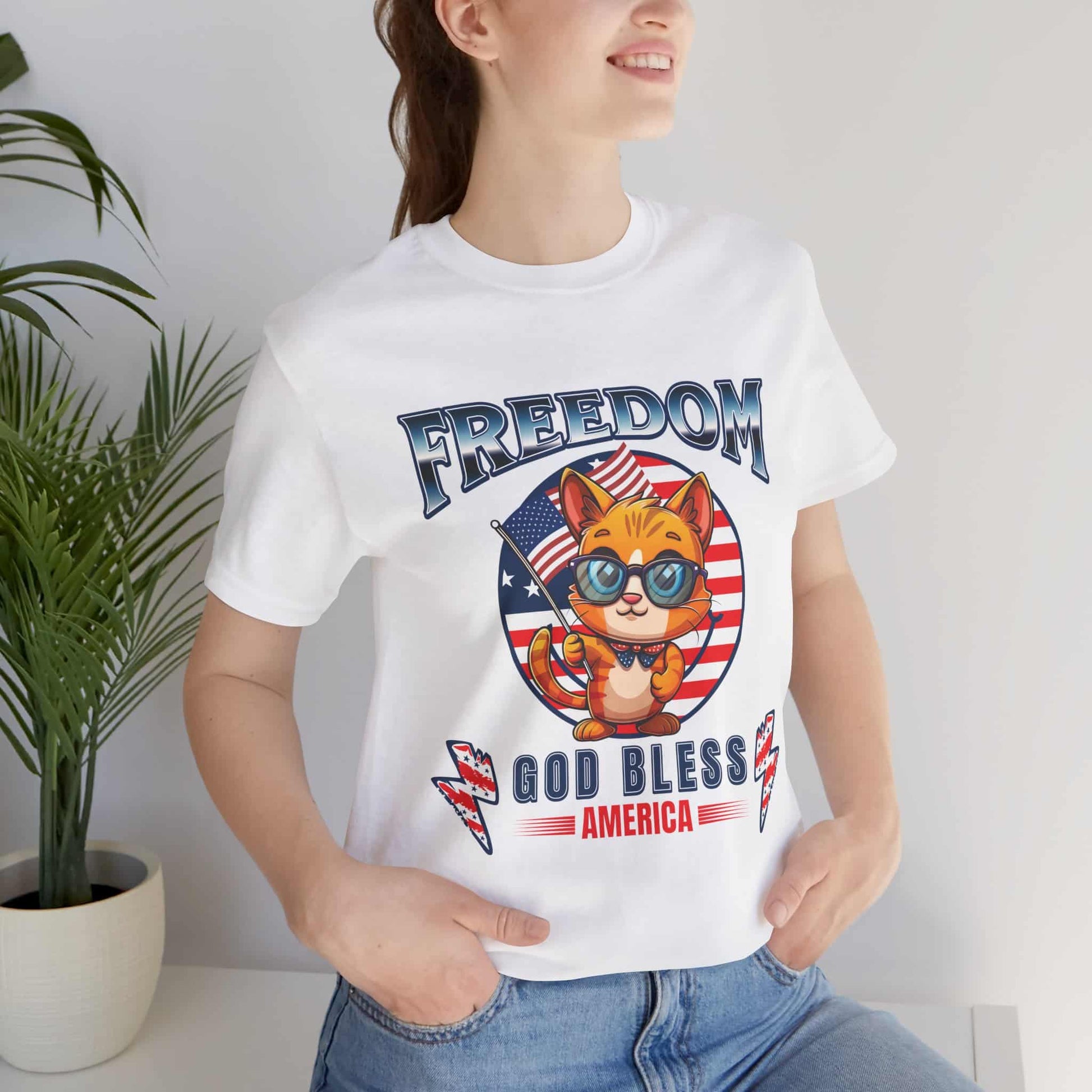 A white Patriotic Cat Freedom T-Shirt worn by a woman, featuring a cat graphic celebrating freedom and American pride.