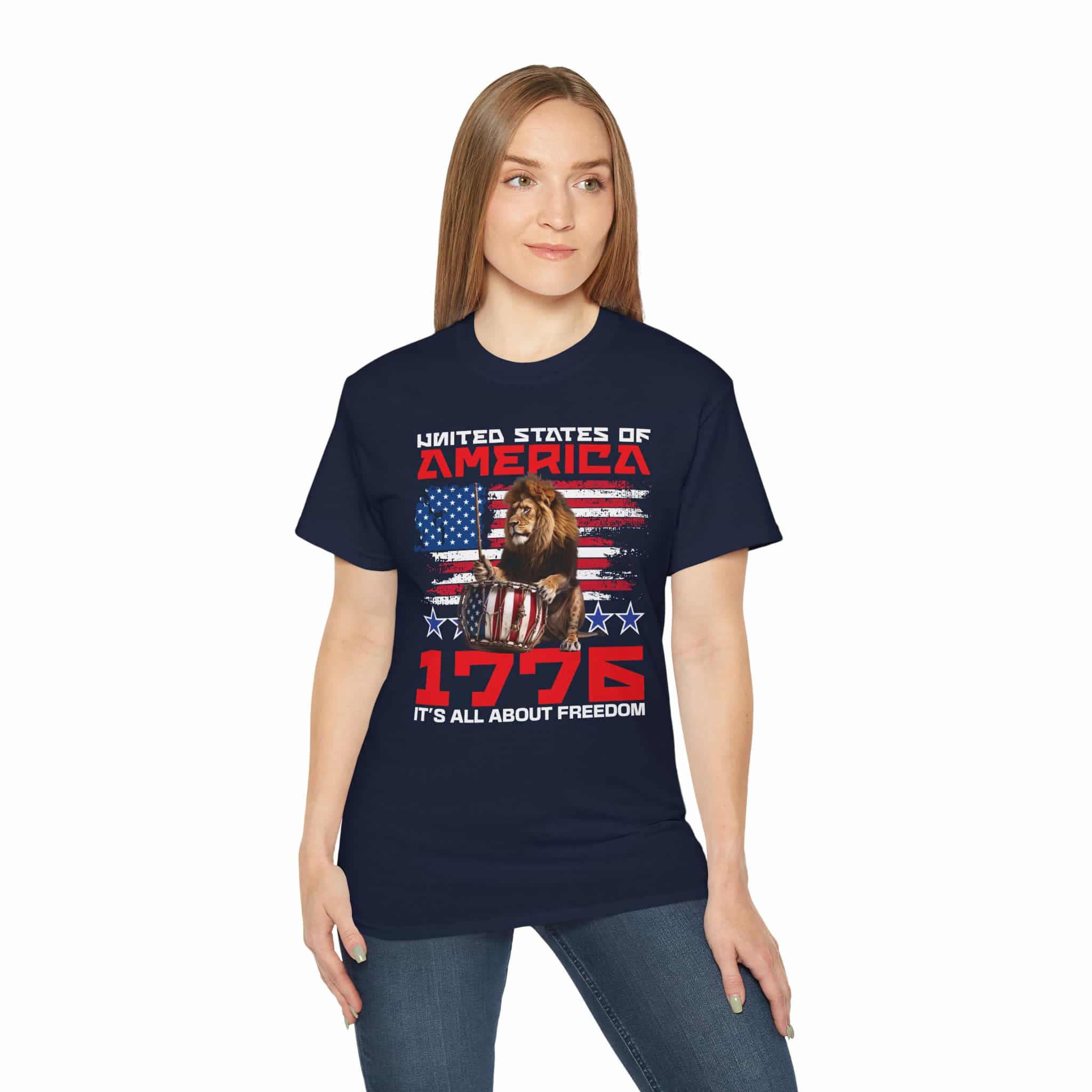 A woman wearing a navy blue It's All About Freedom T-Shirt featuring a drum-playing lion, the American flag, and the text 'It's All About Freedom'.