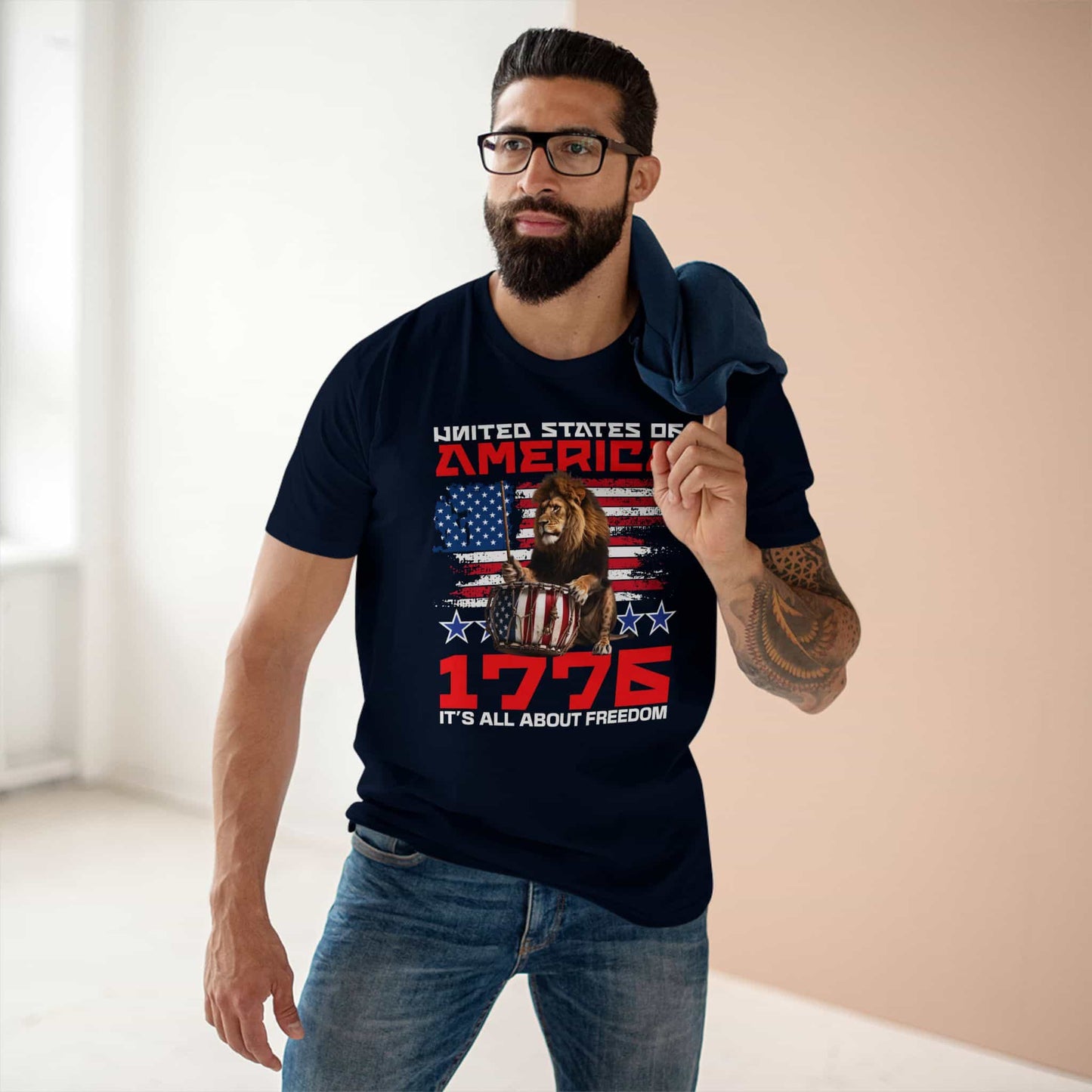 A man wearing a navy blue Patriotic Lion Freedom T-Shirt featuring a drum-playing lion and the American flag for national pride and freedom.