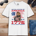 A white It's All About Freedom T-Shirt featuring a drum-playing lion, the American flag, and the text 'It's All About Freedom'.