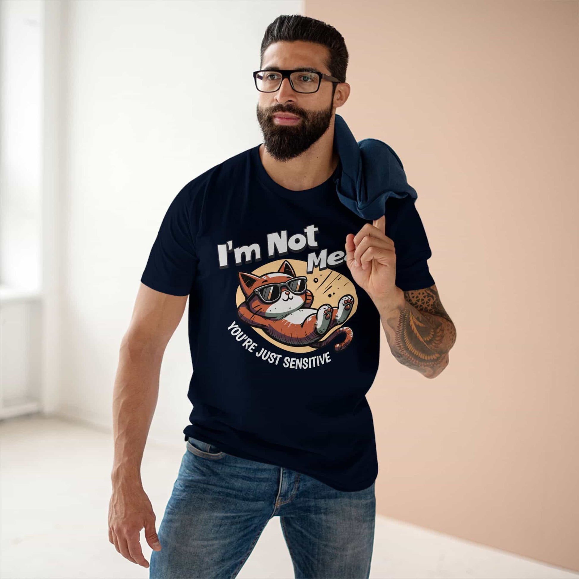 A man wearing a navy blue Sarcastic Cat Humor T-Shirt with a graphic of a cat wearing sunglasses and the text 'I'm Not Mean, You're Just Sensitive'.