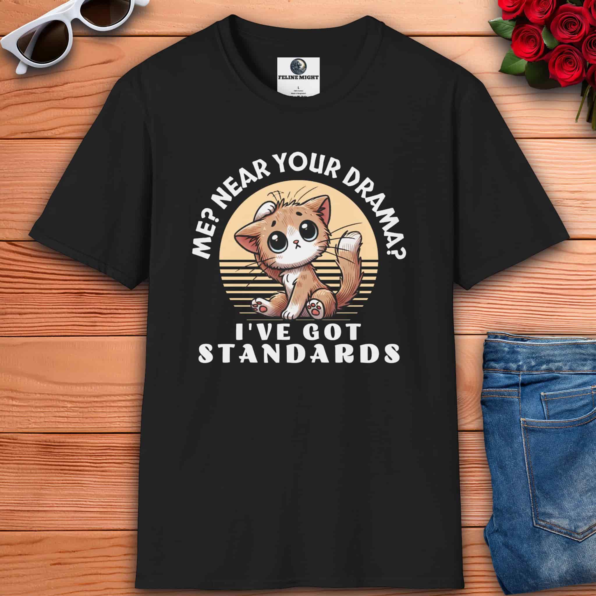 A black Sassy Cat Funny T-Shirt featuring a humorous design with a cute cat and text saying 'Me? Near Your Drama? I've Got Standards.'
