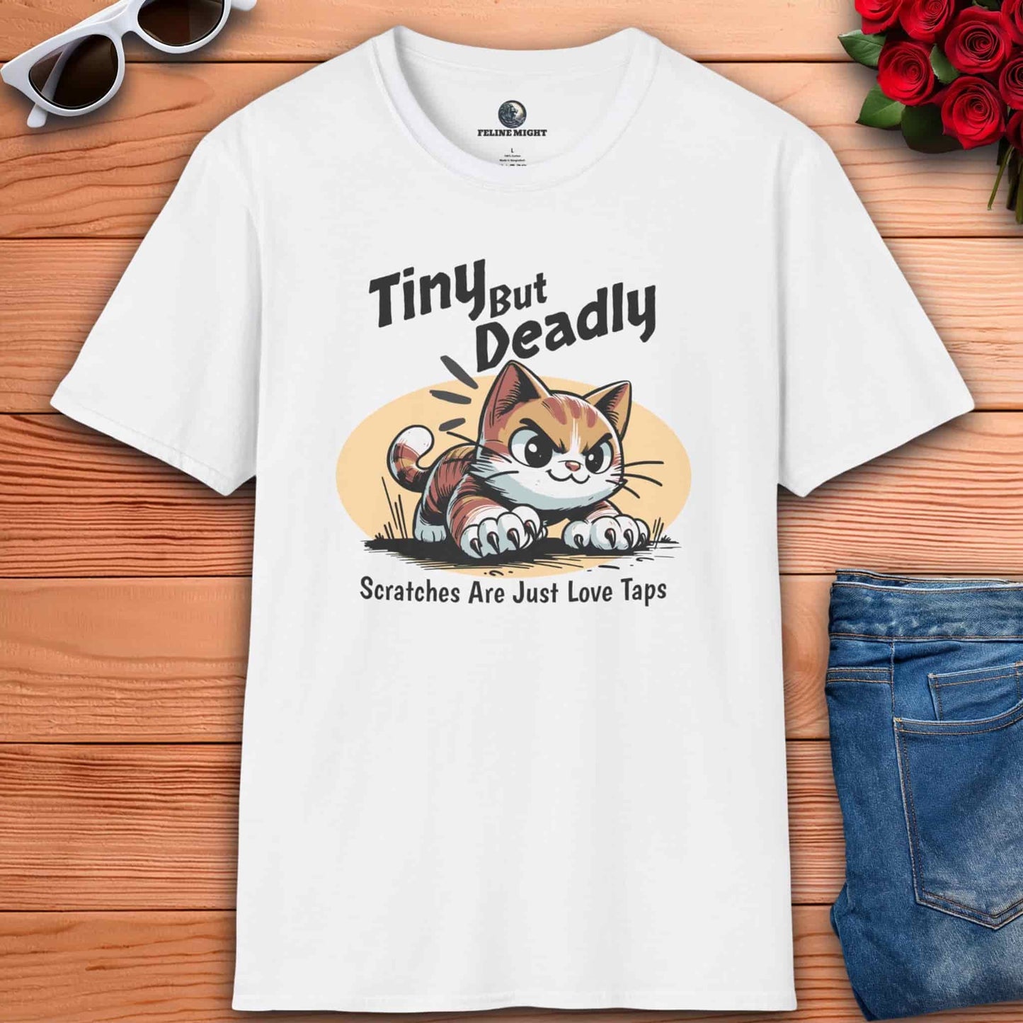 White t-shirt featuring a playful cat graphic with the phrase 'Tiny But Deadly' and 'Scratches Are Just Love Taps'.