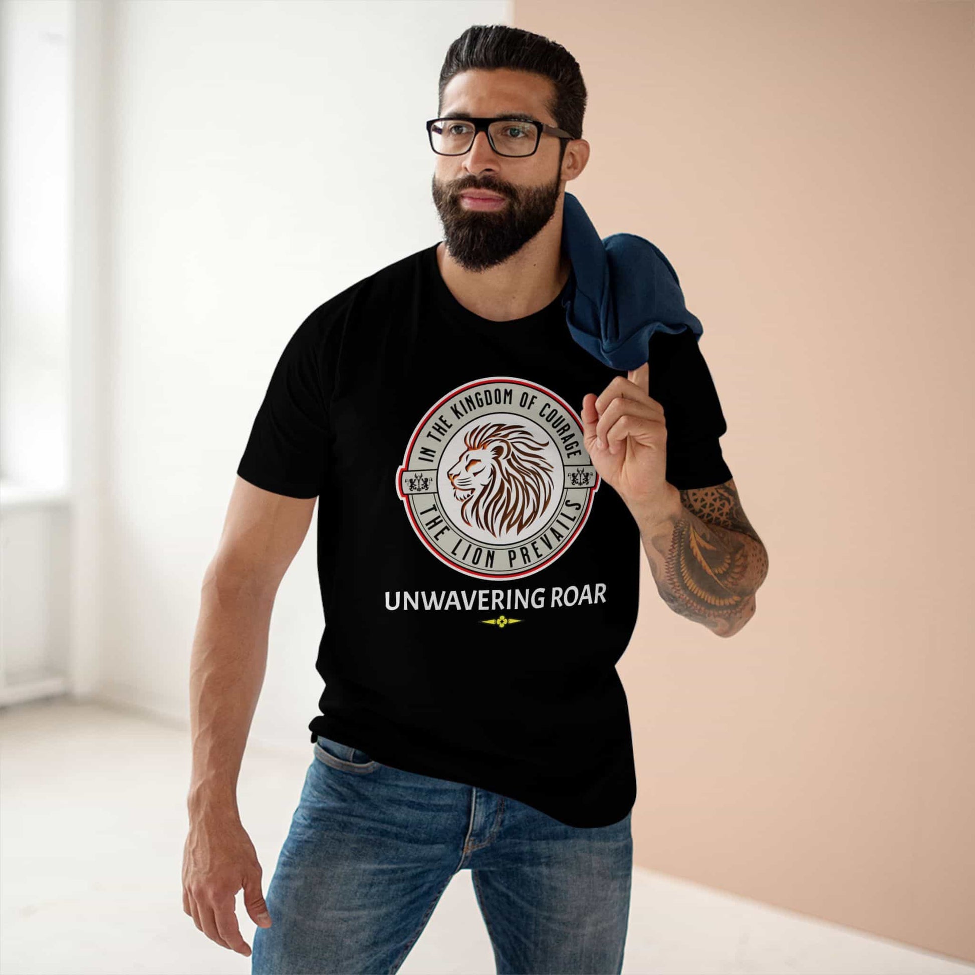 A man wearing a Unwavering Roar Lion T-Shirt featuring a lion graphic and bold text design on a black unisex premium tee, standing indoors.