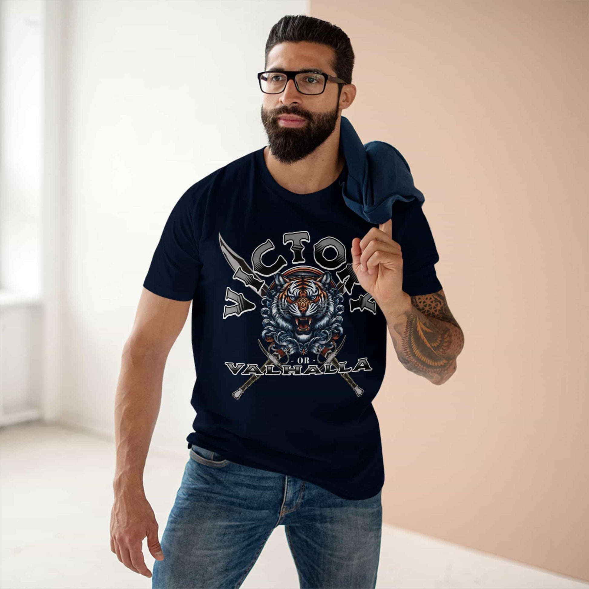 A man wearing a navy blue Victory or Valhalla Tiger T-Shirt featuring bold design with tiger and crossed swords.