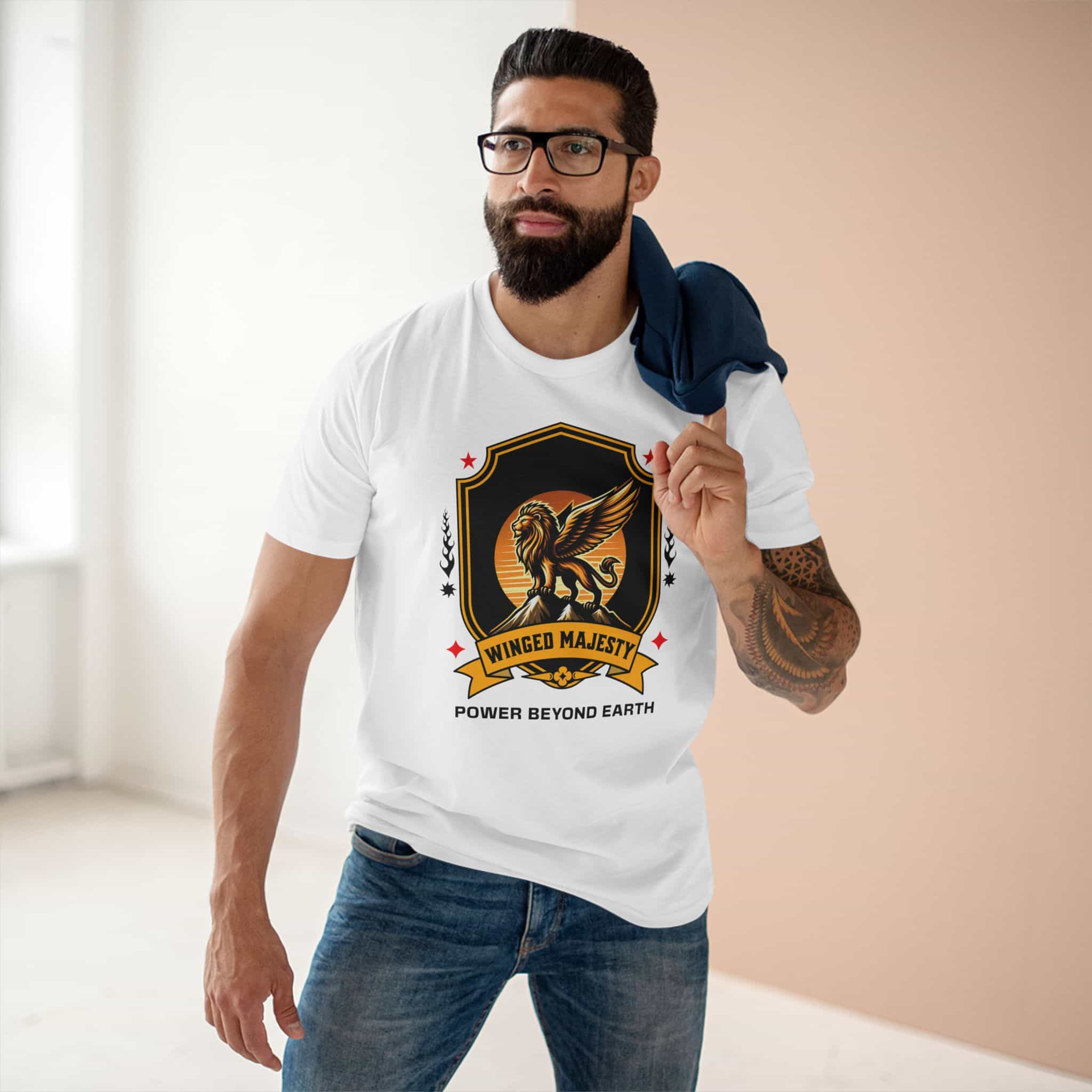 A man wearing a white Winged Majesty Lion T-Shirt featuring a golden-winged lion graphic and the text 'Power Beyond Earth', standing indoors.
